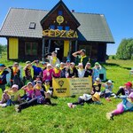 grupa dzieci pozuje do zdjęcia przed siedzibą miodowych skautów
