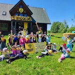 grupa dzieci pozuje do zdjęcia przed siedzibą miodowych skautów