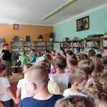 dzieci zwiedzają bibliotekę i czytelnię.