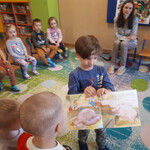 Wojtuś pokazuje dzieciom obrazki w książce