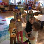 dzieci podnoszą do góry kolorowe okrągłe kartoniki.jpg