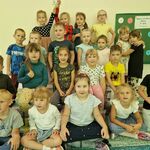 Dzieci w kropkowych ubraniach ustawione są na dywanie_ w tle tablica z kropkami 