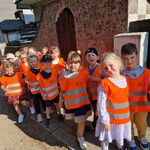Dzieci ustawione parami stoją na chodniku