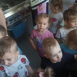 Grupa dzieci w kuchni_ w tle kuchenki gazowe.