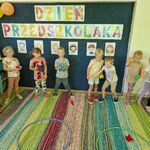 2 Grupa dzieci rzuca woreczkami do obręczy.jpg