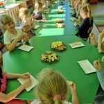 7 Dzieci siedzą przy połączonych stołach_ częstując się owocami.jpg