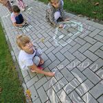 8 Troje dzieci w pozycji przykucniętej_ rysuje kredą na kostce chodnikowej.jpg