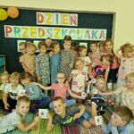 10 Dzieci prezentują medale_ w tle tablica z napisem Dzień Przedszkolaka.jpg