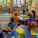 Czytanie 4 Dzieci siedzą przy stolikach i wykonują pracę plastyczną.jpg