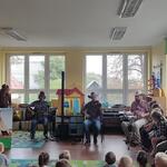 muzycy grają na instrumentach kobieta trzyma rysunek z tipi