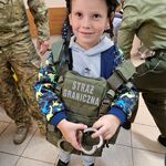 5 Chłopiec trzyma w ręku kajdanki i ma założoną kamizelkę kuloodporną i hełm.jpg