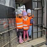Grupa dzieci stoi w pojeździe Straży Granicznej.
