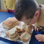 Chłopiec wącha świeżo upieczony chlebek.