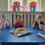 Starszaki przy stoliku jedzą chleb z dżemem.