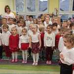 dzieci śpiewające hymn na baczność