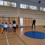 Dzieci współzawodniczą z psem w przeciąganiu liny.