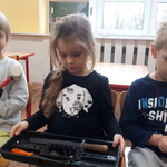 Dzieci oglądają narzędzia stolarskie potrzebne do budowy karmnika.