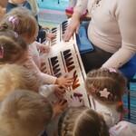 pani fryzjerka trzyma paletę kolorów_ wokół zaciekawione dzieci.