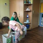 dziecko wrzuca odpady do pojemnika ze szkłem.