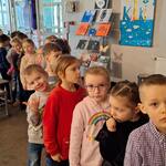 Dzieci stoją w holu teatralnym ustawione w rzędzie.