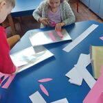 dzieci wykonują królicze uszy z papieru
