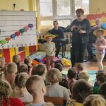 dziewczynki w chińskich kapeluszach i z pałeczkami w rękach.