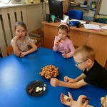 Kilkoro dzieci przy stoliku degustuje różne rodzaje czekolady.