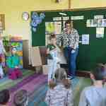 dziewczynka z workiem cukierków obok kobieta i dzieci w sali przedszkolnej