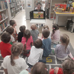 Bibliotekarka pokazuje dzieciom teatrzyk kamishibai pt. Magiczna gąsienica