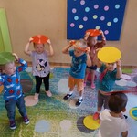 grupa dzieci trzymająca na głowie plastikowe krążki