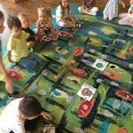 sześcioro dzieci przygląda się jak chłopak układa puzzle