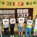dzieci stoją w rzędzie pokazując swoje prace