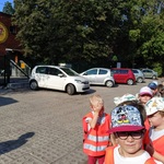 Grupa przedszkolaków idzie obok budynku przdszkola
