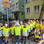 Dzieci stoją i oglądają znak drogowy: Próg zwalniający