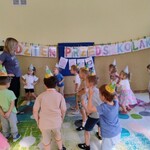 dzieci tańczą w czapeczkach urodzinowych
