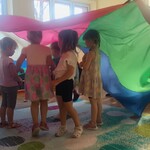 dziewczynki stoją pod kolorową chustą animacyjną