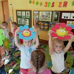 Dzieci tańczą trzymając papierowe kwiatki