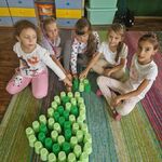 Grupa dziewczynek prezentuje gruszkę ułożoną z kolorowych kubeczków