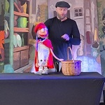 Aktor trzyma pacynkę_ obok niej ustawiony jest koszyk