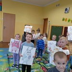 Grupa dzieci tańczy trzymając sylwety zwierząt