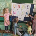 Czworo dzieci znajduje się przy tablicy_ na której jest napis codeweek 2024