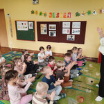 Dzieci toczą w rękach świece z plasterków wosku pszczelego.
