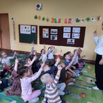 Dzieci pokazują pani własnoręcznie zrobione świece z wosku.