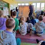 Dzieci siedzą_ przed nimi dwie osoby postawiły jesienne tło.