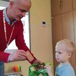 Mężczyzna wręcza upominki dla dziecka.