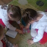dziewczynki ubrane na biało i czerwono_ układają godło - puzle w całość.