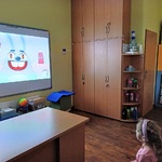 Dzieci oglądają na ekranie królika Higienka myjącego zęby.