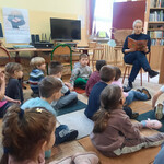 Pani bibliotekarka czyta dzieciom wiersz Jana Brzechwy pt. _Na straganie_.