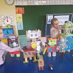 Dwie dziewczynki stoją przy robotach.