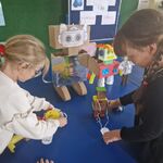Dwie dziewczynki nakładają odznaki robotom.